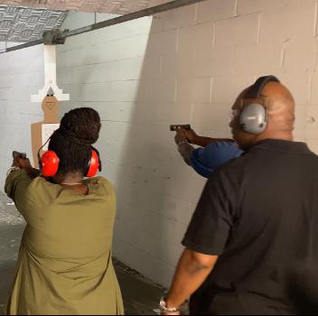 Instructor Hibner on the firing line coaching a student during Handgun Skills and FUNdamentals class  in Atlanta