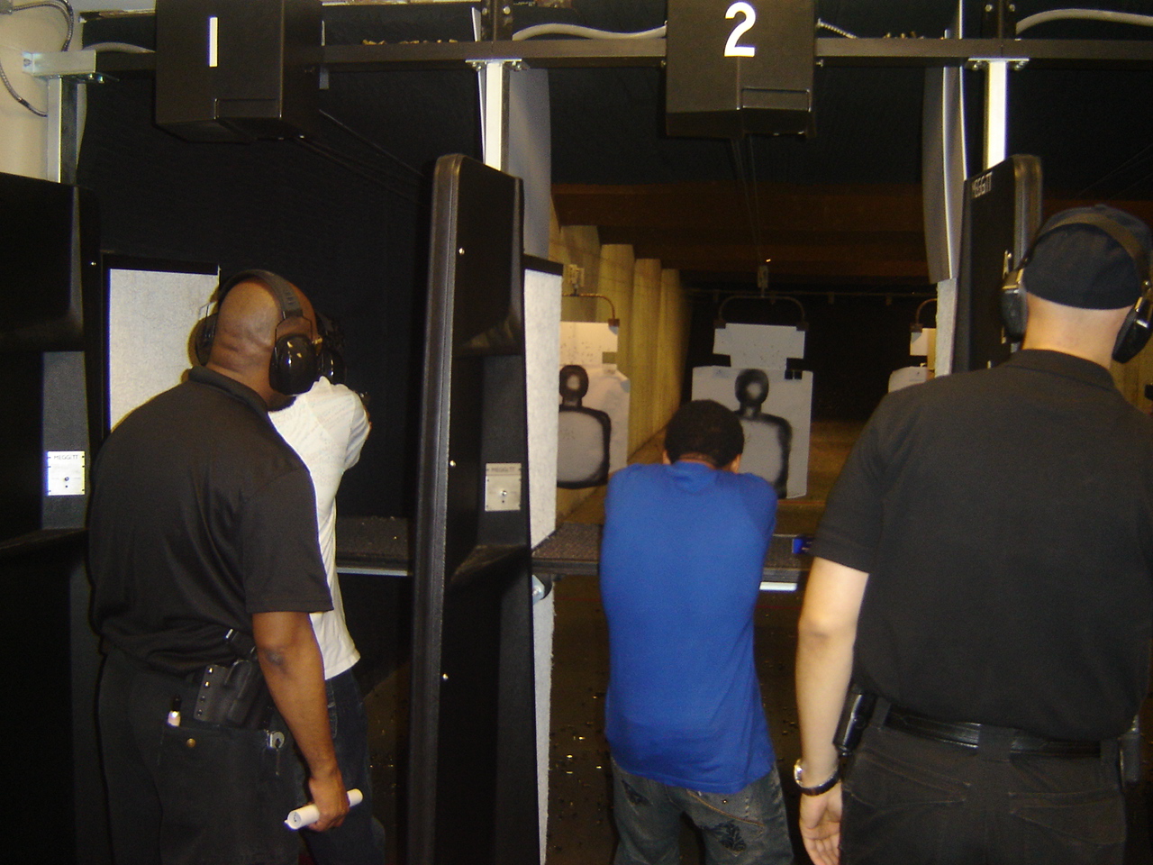 Instructors Leon S. Adams and Joseph Hibner give pointers to new shooters on the firing line